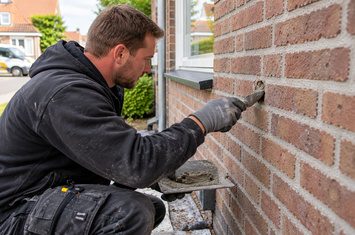 Boorgaten in de gevel afdichten na het aanbrengen van spouwmuurisolatie Isolatiespecialist dicht een boorgat in de bakstenen gevel van een woning na het aanbrengen van spouwmuurisolatie