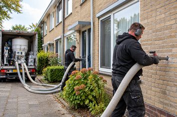 Spouwmuurisolatie aanbrengen bij rijtjeswoningen door isolatiespecialisten Twee isolatiespecialisten brengen spouwmuurisolatie aan bij rijtjeswoningen met behulp van professionele isolatieapparatuur